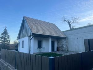 DevičieMalý domček Devičie的白色的房子,有黑色的屋顶和栅栏