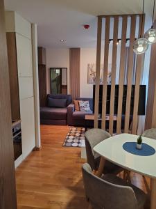una sala de estar con una mesa y un sofá en Brzece lux apartman, en Brzeće