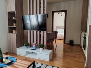 a living room with a flat screen tv on a wall at Brzece lux apartman in Brzeće