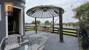 a patio with chairs and an umbrella and a hammock at Apartamento Armonía 01 in Punta Colorada
