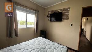 a bedroom with a bed and a tv on the wall at Apartamento Armonía 01 in Punta Colorada