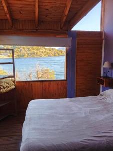 une chambre avec un lit et une grande fenêtre dans l'établissement Patagonia Andina, a metros del lago, excelente vista, à Villa Pehuenia