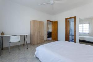 a bedroom with a bed and a table and a desk at Valdeazahares House in El Puerto de Santa María +8 photos