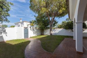 a house with a white fence and a yard at Valdeazahares House in El Puerto de Santa María