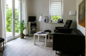 ein Wohnzimmer mit einem Sofa und einem Tisch in der Unterkunft BerLietz in Berlin