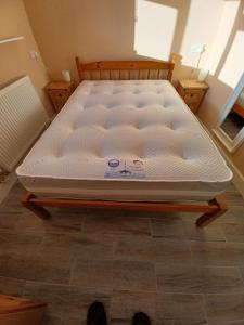 eine Matratze auf einem hölzernen Bettrahmen in einem Zimmer in der Unterkunft Redhouse Farm Cottage the most dog friendly place Ive ever stayed in Withernsea