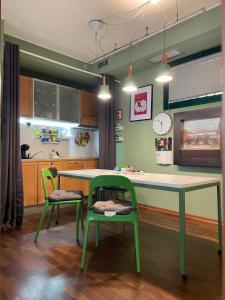 een keuken met een tafel en twee groene stoelen bij La Maison de Fuecopared in Florence