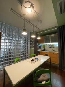 een keuken met een witte tafel en groene stoelen bij La Maison de Fuecopared in Florence