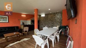 una sala da pranzo con tavolo e sedie bianchi di Casa de Vacaciones Armonía a Punta Colorada