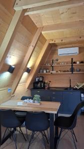 a kitchen with a table and chairs in a room at Stone Chalets - TERRA in Jajce