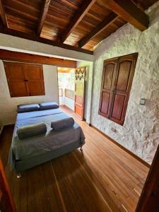 a bedroom with a bed and a wooden floor at Tranquilidad y Naturaleza Cabaña Concepción in Concepción