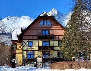 a large house in the mountains with snow at Vila Park in Tatranská Lomnica
