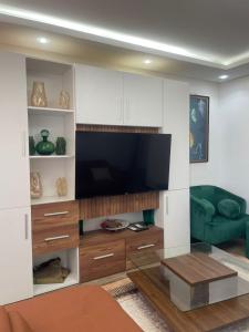 a living room with a large tv and a couch at BBImmo APPART HOTEL in Dakar
