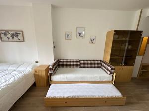 a living room with two beds and a cabinet at Casa Del Tramonto-Golden House in Dosso