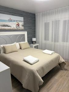una camera da letto con un letto grande con due asciugamani sopra di Apartamentos turísticos ilusiones a Cazalla de la Sierra