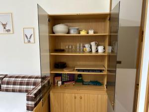 a kitchen with wooden shelves and a refrigerator at Casa Del Tramonto-Golden House in Dosso +36 photos