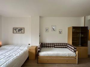 a bedroom with a bed and a wooden cabinet at Casa Del Tramonto-Golden House in Dosso