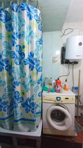 een keuken met een wasmachine en een douchegordijn bij Run İn Joy Hostel in Qostanaj