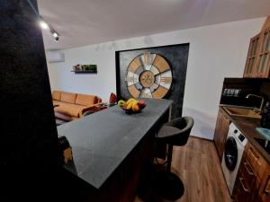 a kitchen with a counter with a bowl of fruit on it at Rebeka Luxury Apartment in Tryavna
