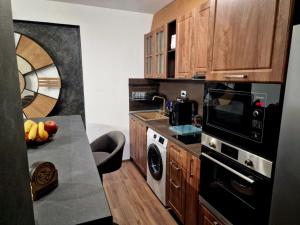 a kitchen with wooden cabinets and a table with fruit on it at Rebeka Luxury Apartment in Tryavna