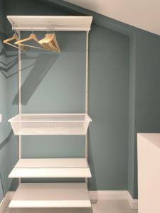 a walk in closet with white shelves at Appartamento Hokusai in Brescia +7 photos