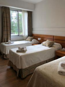 a hotel room with two beds and a window at Parque Hotel in Villa Carlos Paz