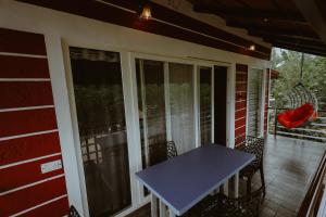 a porch with a blue table and chairs on it at Mountain Peak Resort in Hassan