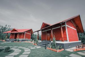 two wooden houses with a lawn in front of them at Mountain Peak Resort in Hassan