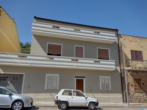 a white car parked in front of a building at Daniela House in Gonnesa