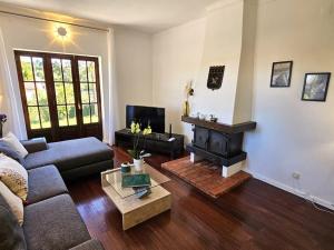 a living room with a couch and a fireplace at 4 chambres, piscine Casa Oleias by SesimbraSunSea in Sesimbra