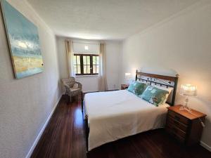 a bedroom with a bed and a chair and a window at 4 chambres, piscine Casa Oleias by SesimbraSunSea in Sesimbra +71 photos