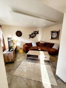 a living room with a couch and a table at Maison chez Jacky au calme avec parking Deux salles de bain in Soufflenheim