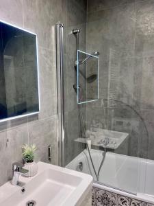 a bathroom with a sink and a glass shower at Panorama Apartment Šamorín in Šamorín +6 photos