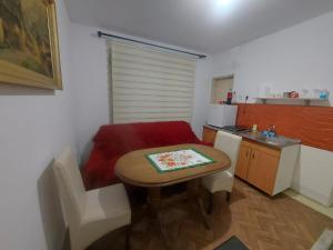 a small kitchen with a table and a small table and chairs at Smeštaj Gokčanica in Gokčanica