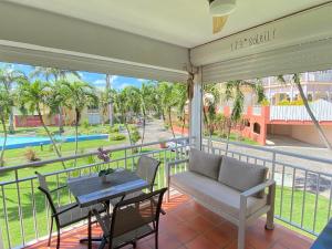 a balcony with a table and chairs and a view of a pool at Domaine de l'Anse des Rochers in Saint-François