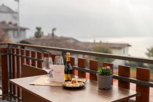 a bottle of wine and glasses on a table on a balcony at Lago di Sole X 6 Point Break in Marone