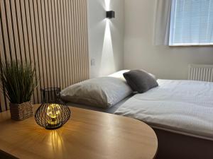 ein Schlafzimmer mit einem Bett und einem Tisch mit einer Lampe in der Unterkunft Apartmán Branisko - Nový Smokovec in Starý Smokovec