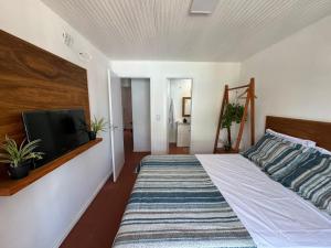 a bedroom with a bed and a flat screen tv at CANTINHO da ARMAÇAO in Búzios