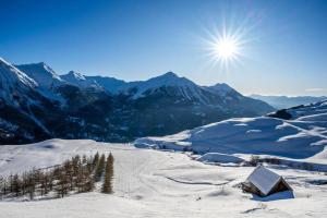 einen schneebedeckten Berg mit der Sonne am Himmel in der Unterkunft Appartement au pied des pistes in Forest des Baniols