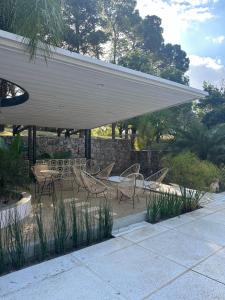 a group of chairs and tables under a pavilion at Parque Hotel in Villa Carlos Paz