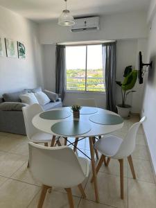 ein Wohnzimmer mit einem Tisch und weißen Stühlen in der Unterkunft El departamento de Mel in Villa Luzuriaga
