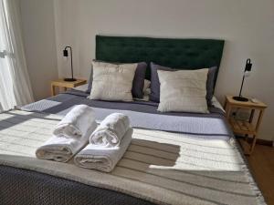 ein Bett mit drei Handtüchern darüber in der Unterkunft El departamento de Mel in Villa Luzuriaga