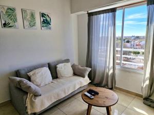 a living room with a couch and a table and a window at El departamento de Mel in Villa Luzuriaga