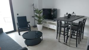 a living room with a table and chairs and a television at LHOME CÁDIZ in Cádiz