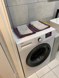 a washing machine with towels on top of it at Reiņu meža Apartaments in Liepāja