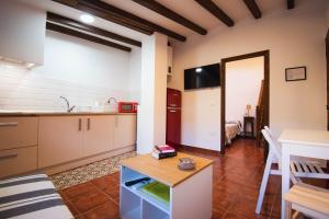 eine Küche und ein Wohnzimmer mit einem Tisch in der Unterkunft Apartamentos El Pozo1 in Villanueva de la Vera