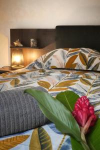 a bedroom with a bed with a red flower on it at Duplex Toti la - TropicalKaz Guadeloupe in Bouillante