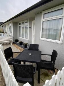 a black table and chairs in front of a house at Sandy Paws in Trusthorpe