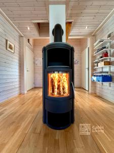 a fireplace in the middle of a room with wood floors at Cabin at Sjusjøen Birkebeiner trail ski in out, 8 beds, 2 bathrooms & Wifi in Sjusjøen