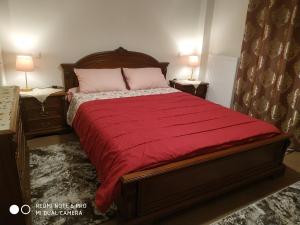 a bedroom with a large bed with a red blanket at Villa Krina Rosa Aigio in Elíki
